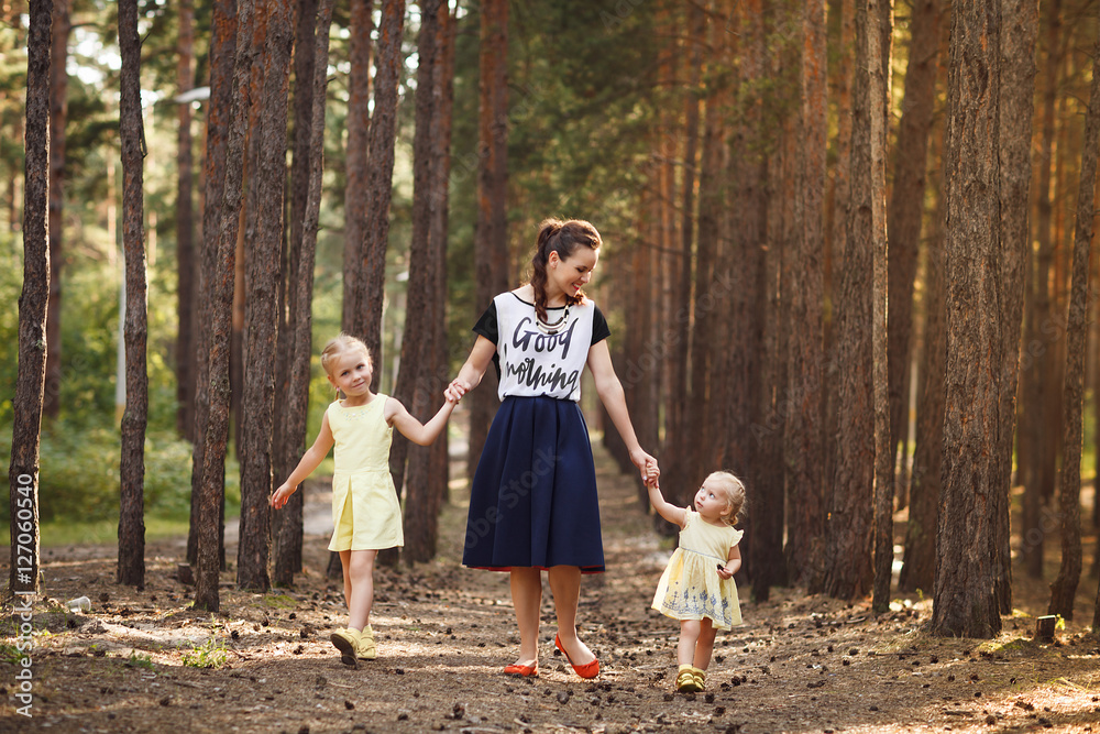 Mother and two little daughters walking in the forest. Family en Mother and two little daughters walking in the forest. Family en