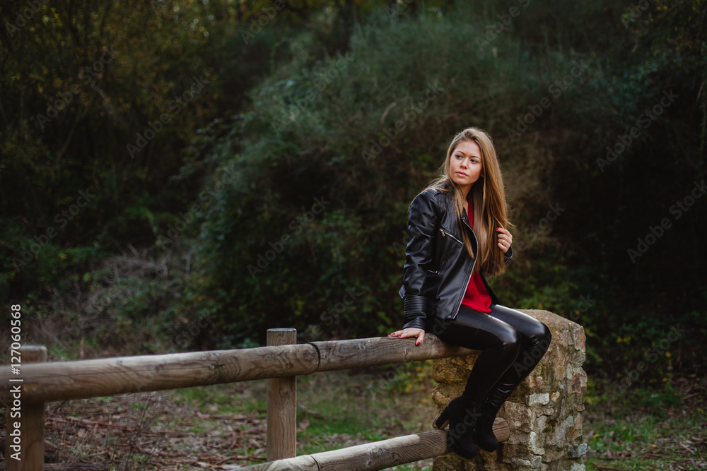 Cool blonde girl sitting on a wooden fence Cool blonde girl sitting on a wooden fence