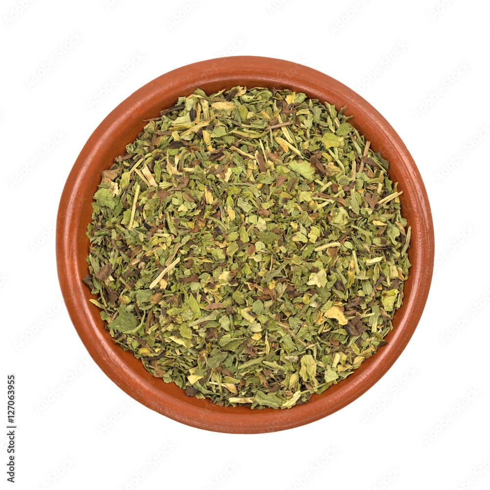 Small bowl of feverfew herb on a white background.
