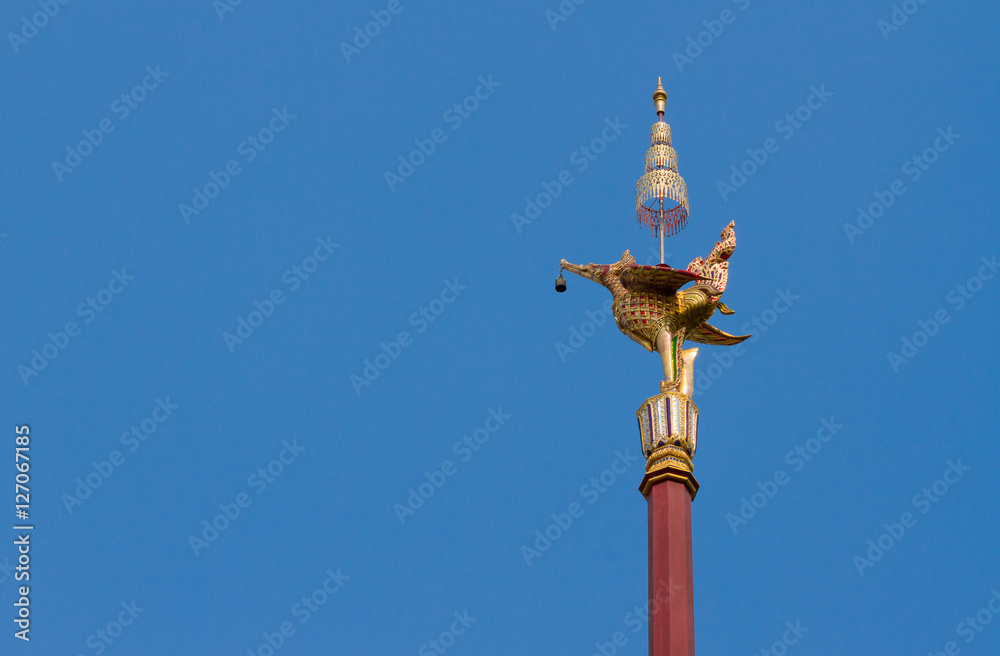 Thai style golden bird lamp statue and blue sky