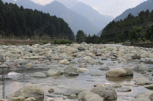 Beautiful scenic Lidder river flowing through Pahalgam Valley in Jammu & Kashmir. People enjoying here around the world. photo