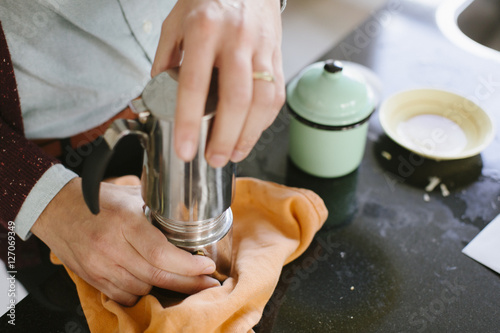 a man preparing coffee with a percolator photo