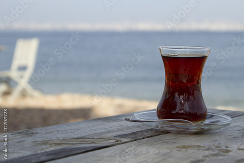 Traditional turkish glass of tea on the old wooden table near se photo