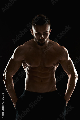 very muscular man posing with naked torso in studio © nazarovsergey