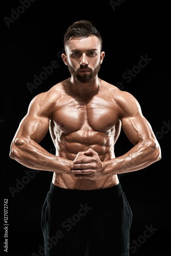 very muscular man posing with naked torso in studio