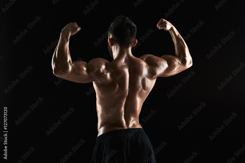 very muscular man posing with naked torso in studio