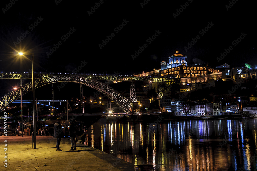 night sight of the bridge Luis 1 and of the river Douro to its step along Oporto, in Portugal