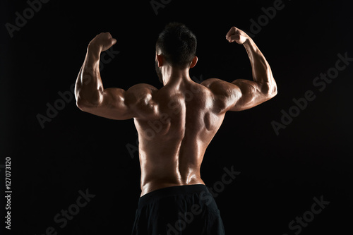 very muscular man posing with naked torso in studio © nazarovsergey