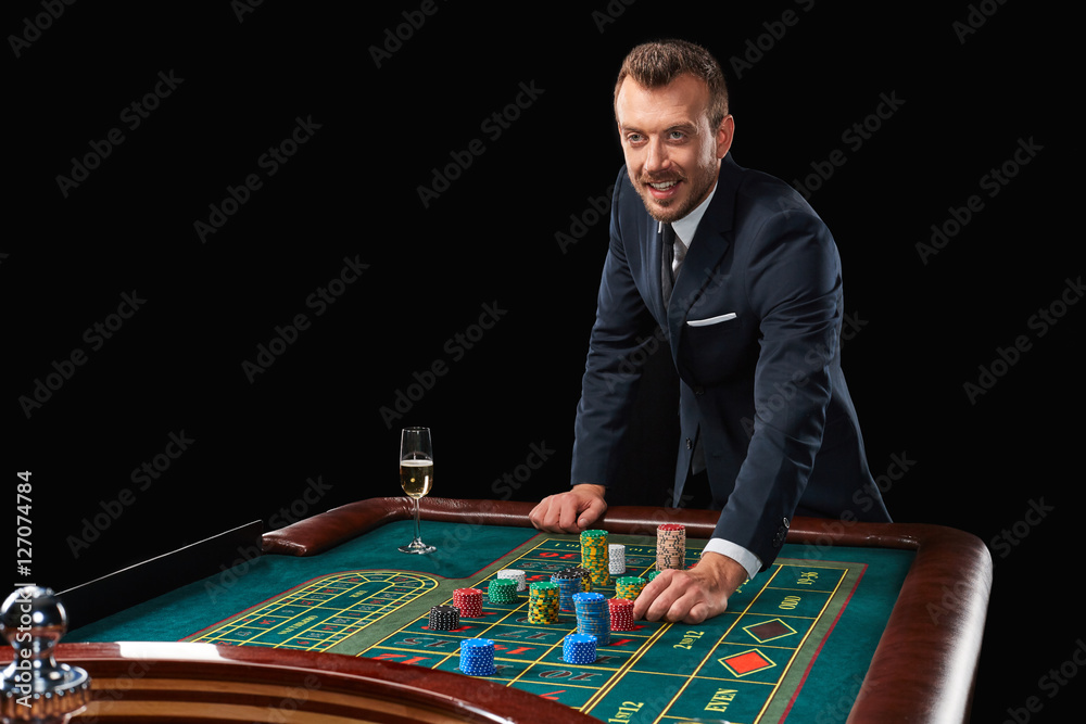 man in suit playing roulette. addiction to gambling. man in suit playing roulette. addiction to gambling.