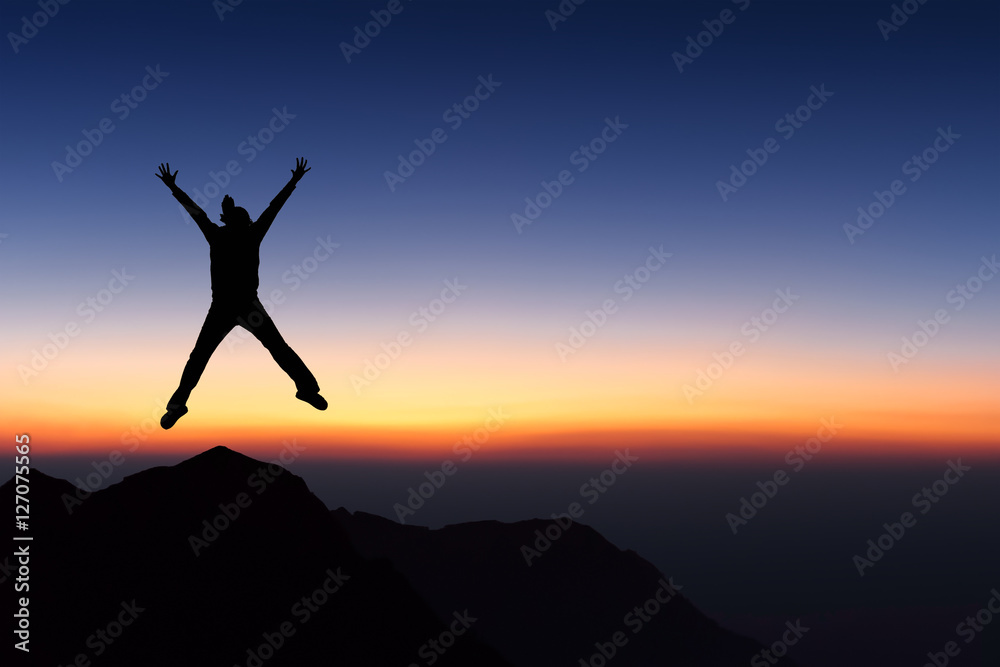 Woman on top of mountain jumping and looking to sunset sky. Woman on top of mountain jumping and looking to sunset sky.