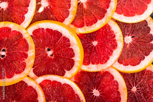 Slices of grapefruits texture, natural backgrounds of citrus fruits, overhead, macro