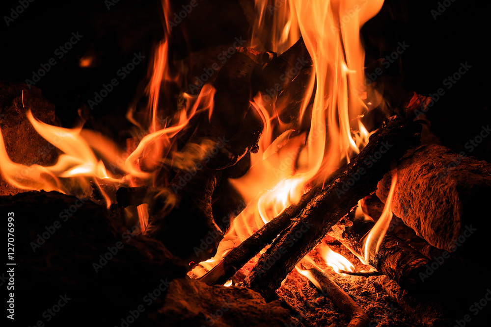 Hot fire flames in the dark. majestic fire at night. a special place on the stone. concept of ecology and use of fire outdoors in travel. used as background Hot fire flames in the dark. majestic fire at night. a special place on the stone. concept of ecology and use of fire outdoors in travel. used as background
