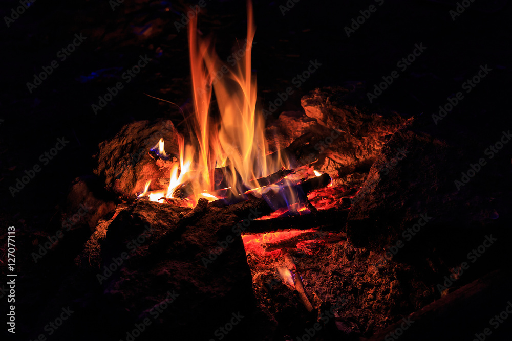 Hot fire flames in the dark. majestic fire at night. a special place on the stone. concept of ecology and use of fire outdoors in travel. used as background Hot fire flames in the dark. majestic fire at night. a special place on the stone. concept of ecology and use of fire outdoors in travel. used as background