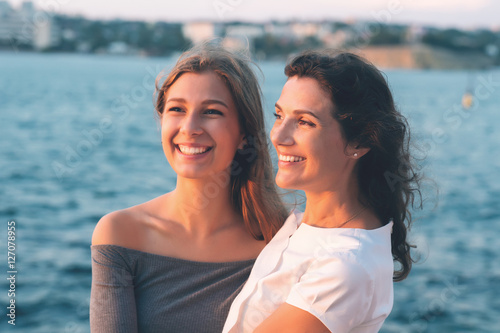 Portrait of happy mother with teenage daughter. Sunset light. Mom holding her teen daughter.