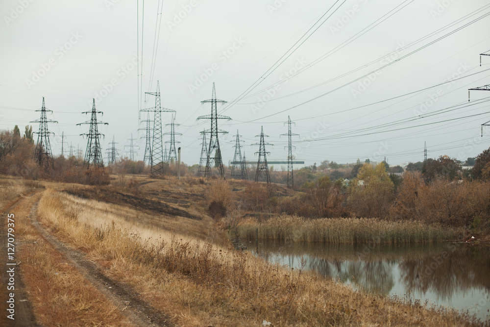 Coal power station in beautiful area full of trees and lake, mirror reflection of energetic pole and power station with chimneys, synergy of industry and nature Coal power station in beautiful area full of trees and lake, mirror reflection of energetic pole and power station with chimneys, synergy of industry and nature