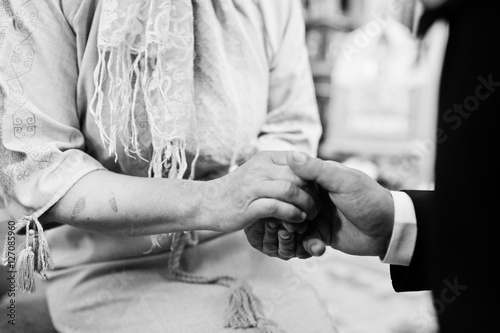 Son hold mother hand at blessings. Groom at church