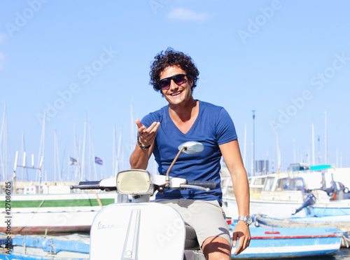 Young Italian Man on Vespa Scooter Smiling © courtyardpix