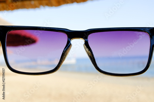 Black sunglasses at sea background