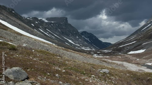 dark clouds are moving over a rocky canyon
