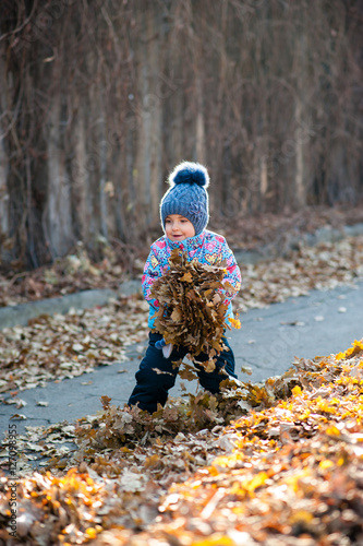 Girl playing with leaves in the Park