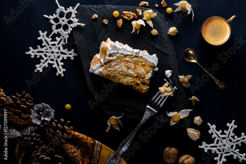 piece of cake and a cup of coffee on a black background decorated with New Year