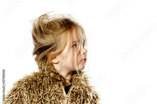 Disheveled preschooler girl with long hair dressed in fur coat photo