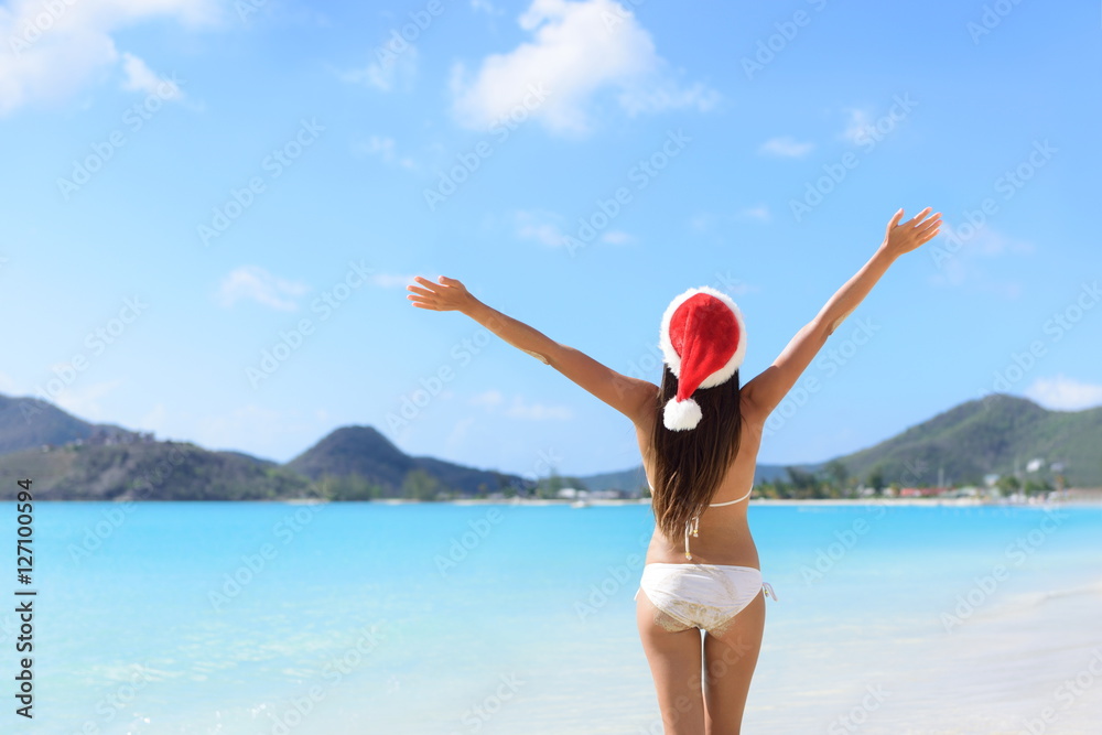 Happy Christmas holiday santa hat woman on beach vacation winning arms up in success. Happy Christmas holiday santa hat woman on beach vacation winning arms up in success.
