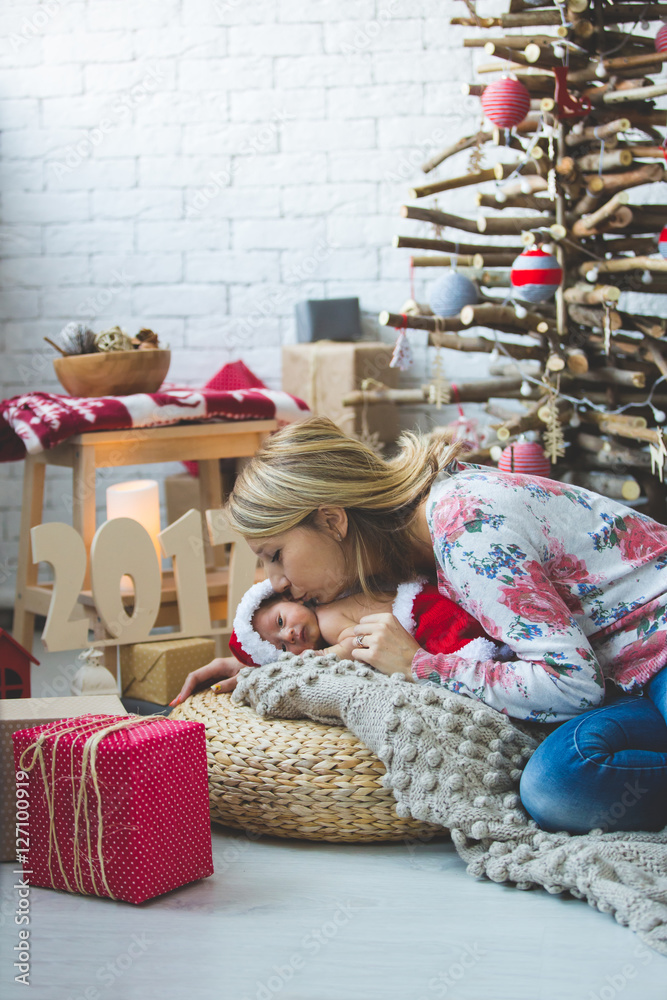 Young woman and her newborn baby  in Santa clothes