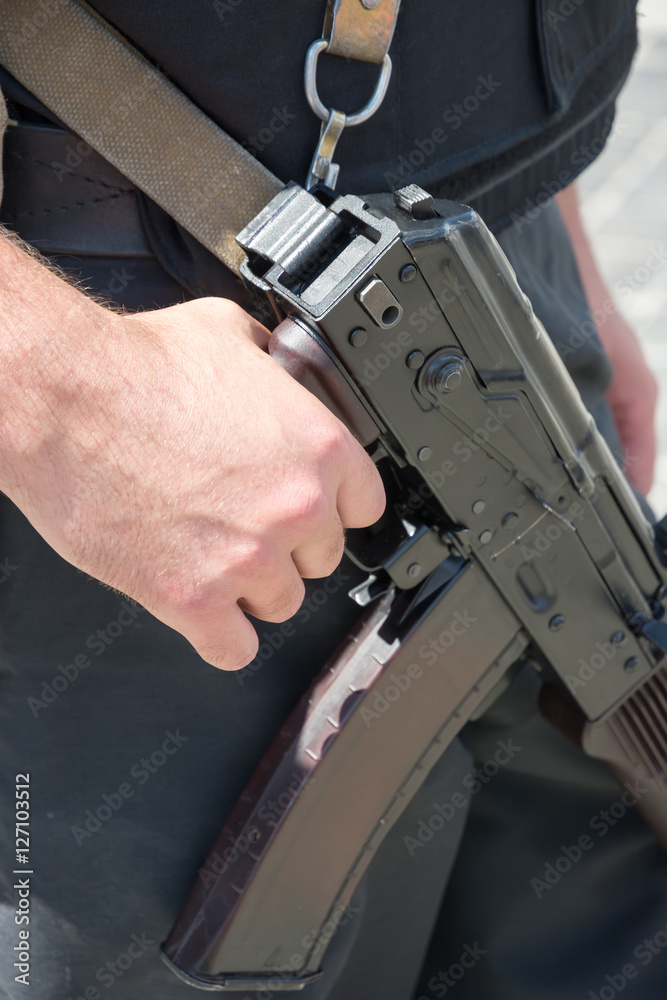 Ukrainian soldier with machine gun. The hand on the machine gun close-up.