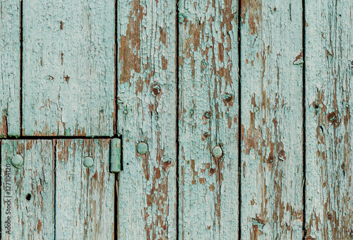 Old wooden wall with green paint peeling off