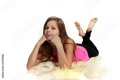 Śliczna dziewczyna, nastolatka leży na baraniej skórze.