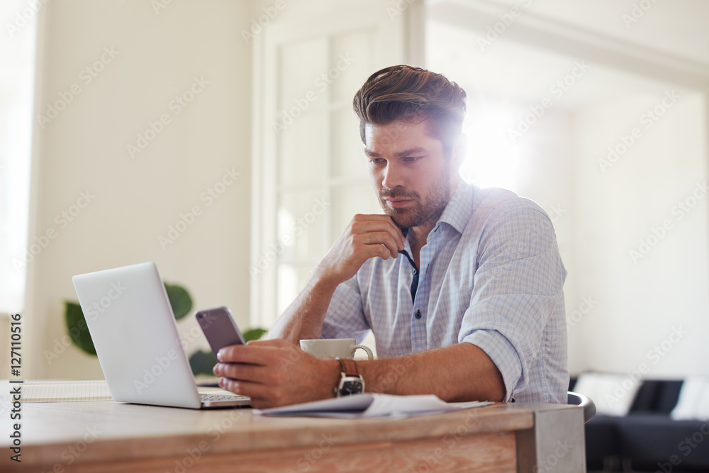 Business man at home office with smart phone and laptop Business man at home office with smart phone and laptop