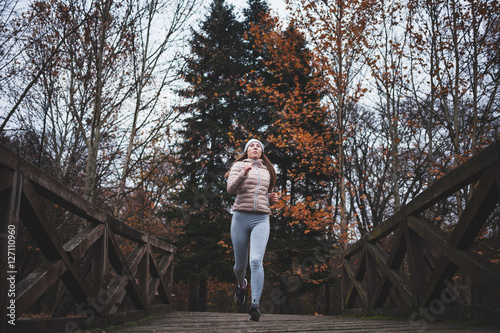 Young woman jogging on a cold day in the park © marjan4782