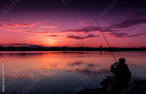 fantastic landscape, multicolor sky over the lake. majestic sunrise. Fishing feeder at sunset. Fisherman silhouette at sunset. use as background. series. creative images.