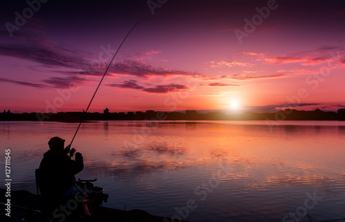 fantastic landscape, multicolor sky over the lake. majestic sunrise. Fishing feeder at sunset. Fisherman silhouette at sunset. use as background. series. creative images.