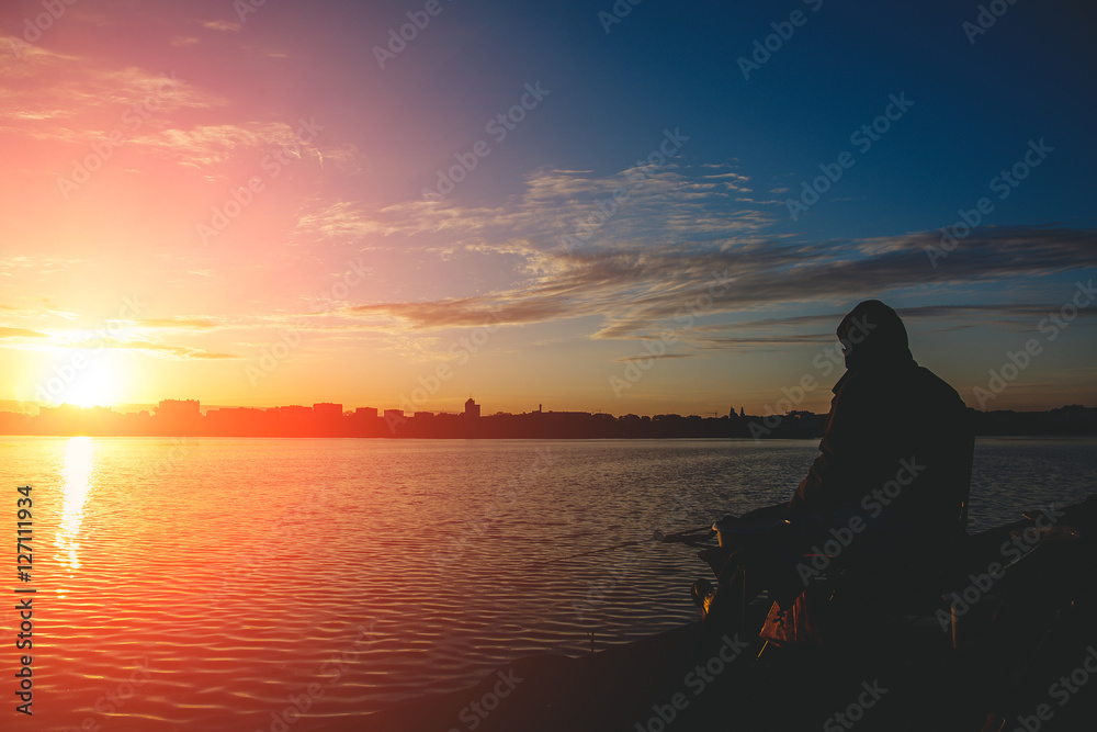 fantastic landscape,colorful sky over the lake. majestic sunrise. Fishing feeder at sunset. Fisherman silhouette at sunset. 