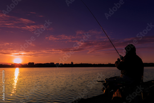 fantastic landscape,colorful sky over the lake. majestic sunrise. Fishing feeder at sunset. Fisherman silhouette at sunset. 