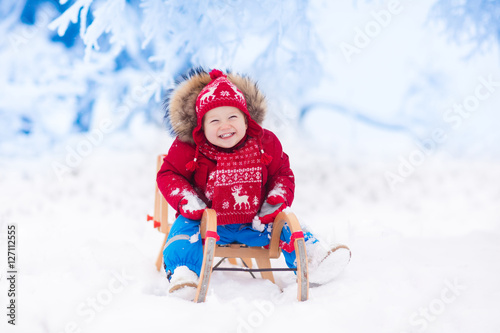 Kids play in snow. Winter sleigh ride for children © famveldman