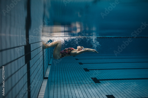 Female swimmer in action inside swimming pool