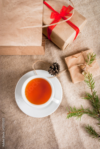 Gift wrapping and letters, cards for Christmas greetings. Envelopes with letters, gifts, Christmas tree branches and pine cones are on a wooden table lie, a cup of fragrant hot tea, top view