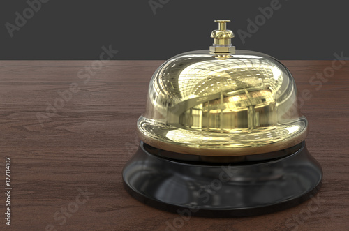 Welcome. 3D render of Brass Reception Bell. Wooden Desk background.