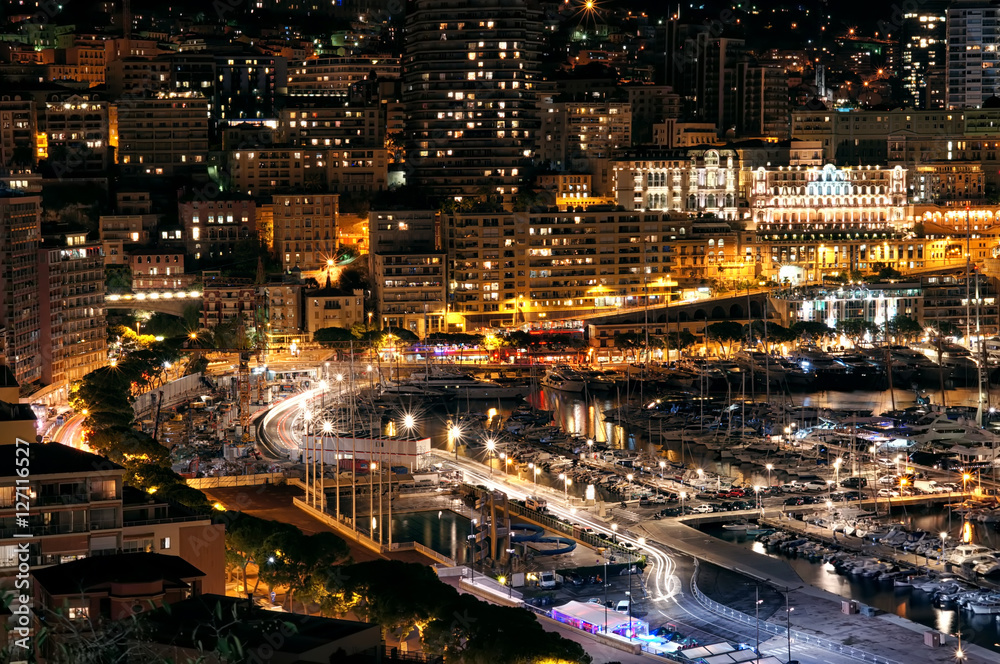 Port and the city at night lights with many luxury yachts in Europe. Monte Carlo, Monaco, France.
