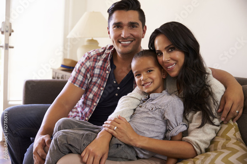 Portrait Of Happy Family Sitting On Sofa In at Home