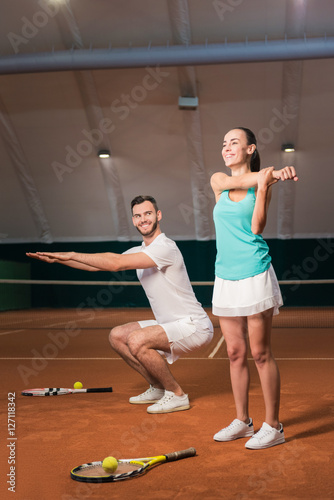 Positive tennis players doing sport exercises