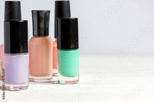 bottles of colored nail polish on wooden background close up
