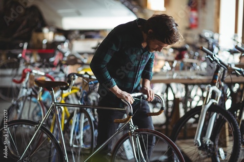 Mechanic examining a bicycle handle bar photo