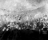 Micro air bubbles in the ice frozen during their movement to the water surface. 1 : 1 macro lens shot. BW photo.