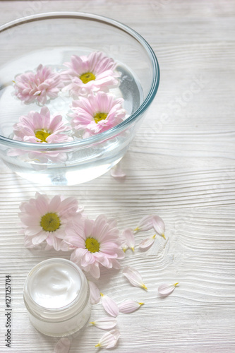 cream and spa on wooden background with flowers