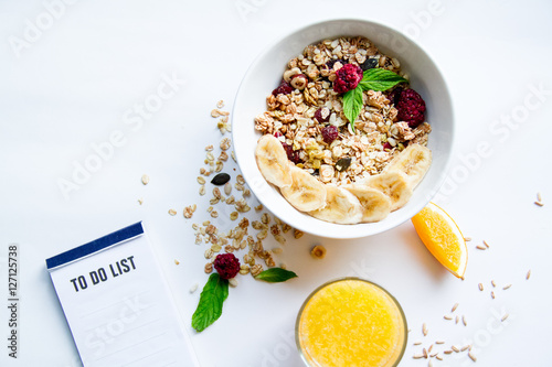 Breakfast with oatmeal and to do list on white background photo