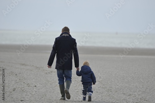 promenade sur la plage père et son enfant se donnant la main photo